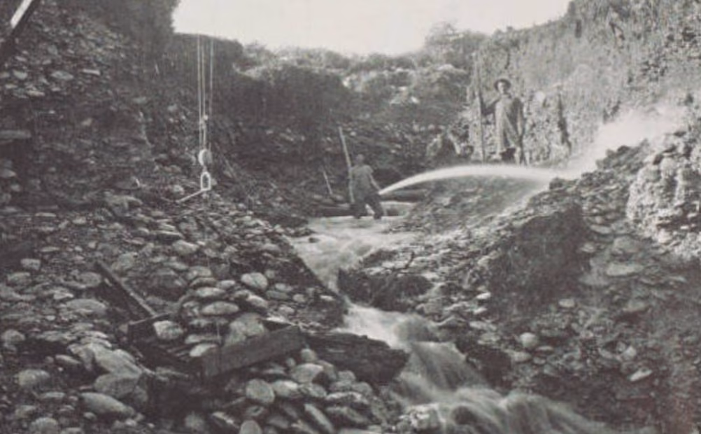Black-and-white photograph showing workers sluicing for alluvial gold at the Nelson Brothers claim in the Wakamarina Valley.